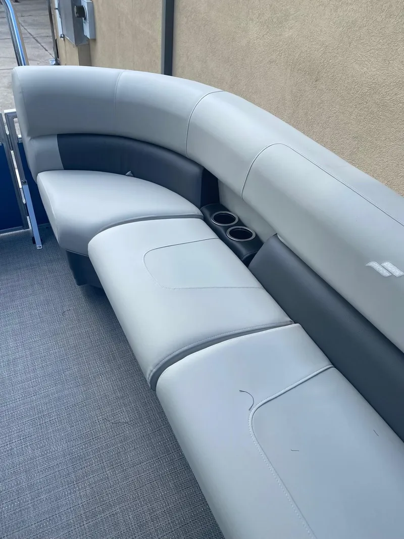 Slide: The Image of 2024 Starcraft LX 20 R boat interior with gray seating and cup holders. - 6