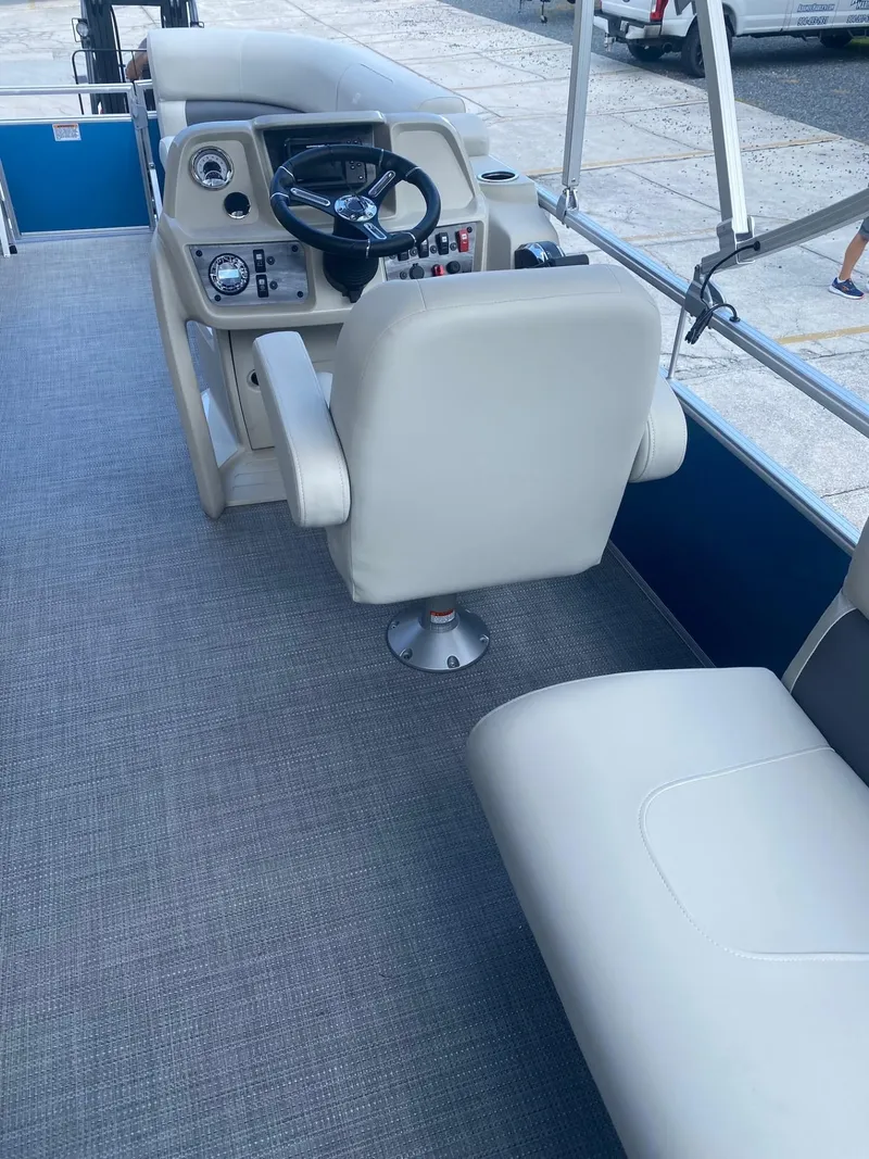 Slide: The Image of 2024 Starcraft LX 20 R boat interior with steering console and seating. - 9