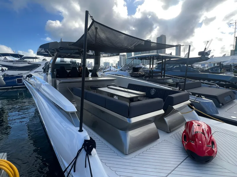 Slide: The Image of 2023 Canados 493 Gladiator yacht docked, featuring sleek design and spacious deck area. - 4