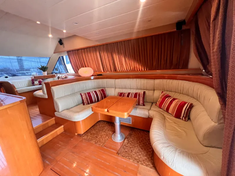 Slide: The Image of Luxurious interior of 2001 Uniesse Flybridge 48 yacht with plush seating and wooden accents. - 16