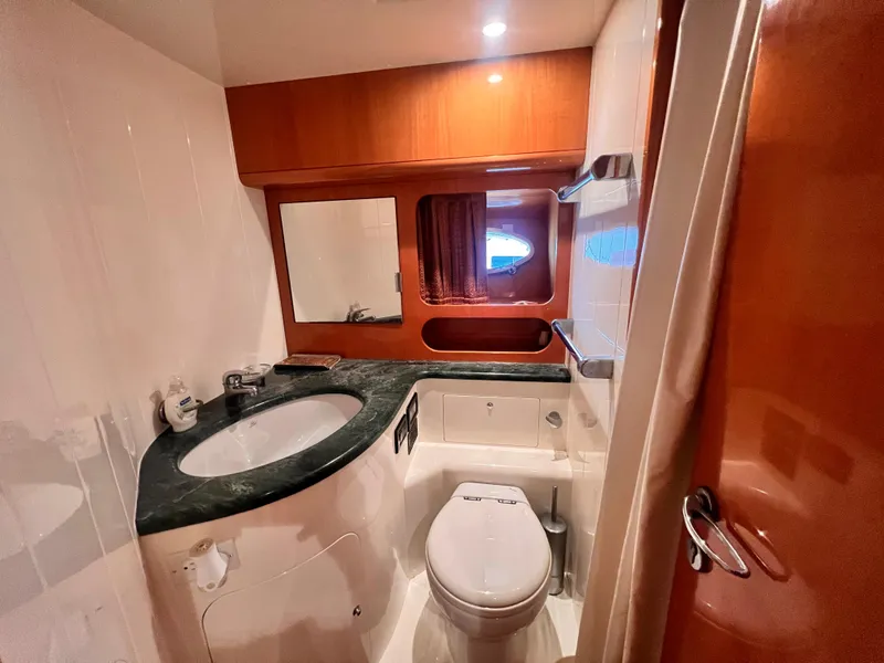 Slide: The Image of Bathroom interior of 2001 Uniesse Flybridge 48 yacht with sink, toilet, and mirror. - 22