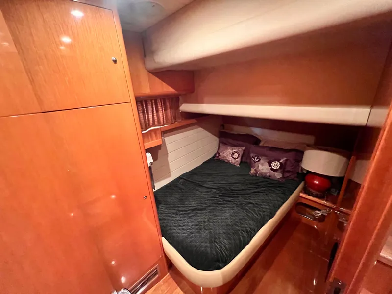 Slide: The Image of 2001 Uniesse Flybridge 48 cabin with cozy bed and wooden interior. - 23