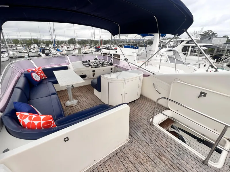 Slide: The Image of 2001 Uniesse Flybridge 48 yacht with spacious deck and seating area in marina. - 26
