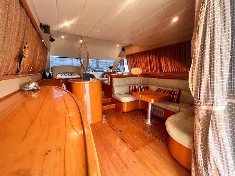 Slide: The Image of Luxurious interior of 2001 Uniesse Flybridge 48 yacht with wooden finishes and cozy seating area. - 5