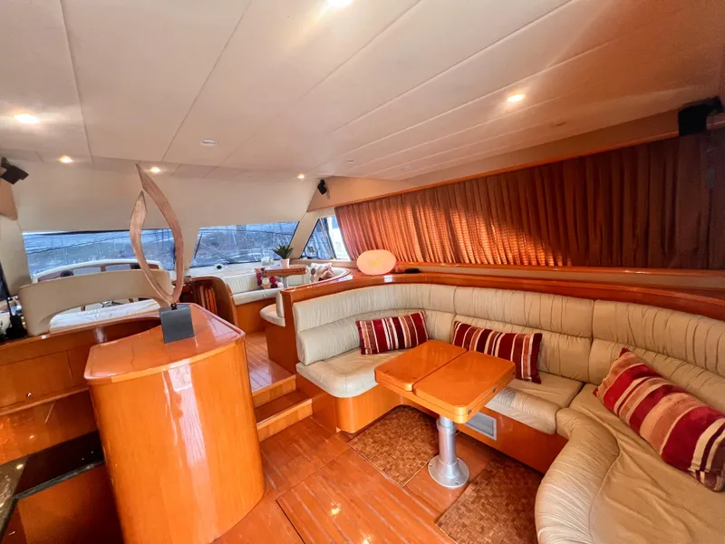Slide: The Image of Luxurious interior of 2001 Uniesse Flybridge 48 yacht with plush seating and wooden finishes. - 6