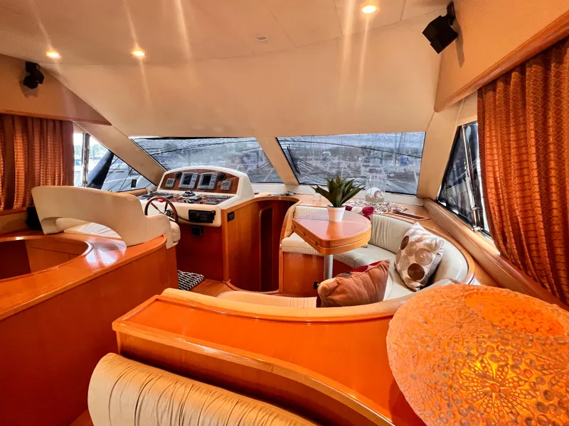 Slide: The Image of Luxurious interior of a 2001 Uniesse Flybridge 48 yacht with plush seating and helm station. - 9