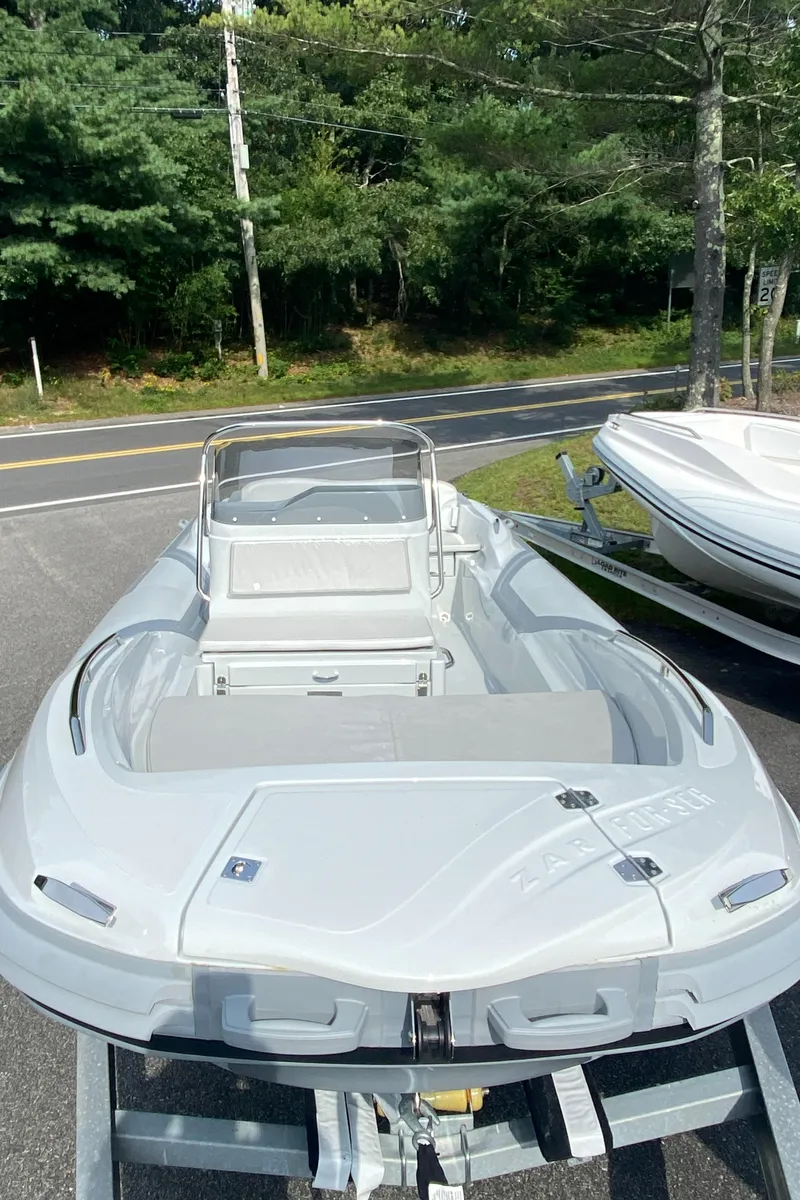 Slide: The Image of 2024 Zar Formenti 53 boat on trailer, parked near a road and trees. - 9