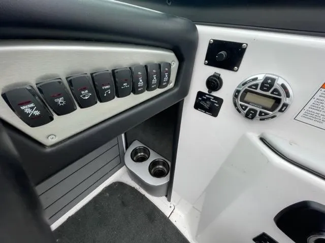 Slide: The Image of Control panel of a 2012 Moomba Mojo 2.5 boat with switches and cup holders. - 13