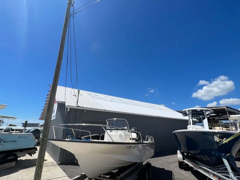Slide: The Image of 2009 Boston Whaler 190 Outrage boat on trailer under clear blue sky. - 2