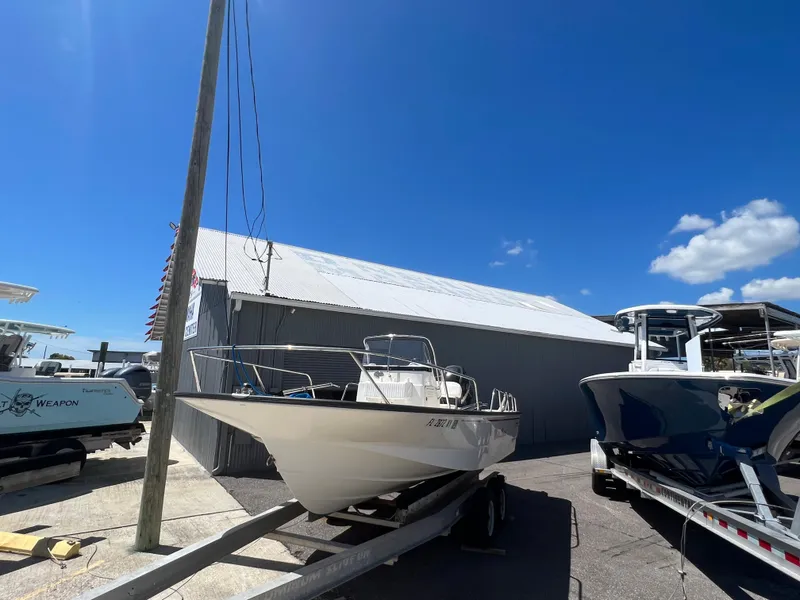 Slide: The Image of 2009 Boston Whaler 190 Outrage boat on a trailer under a clear blue sky. - 3