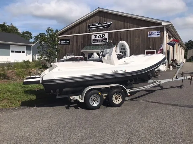 Slide: The Image of 2024 Zar Formenti 59 SL boat on a trailer outside a dealership. - 6