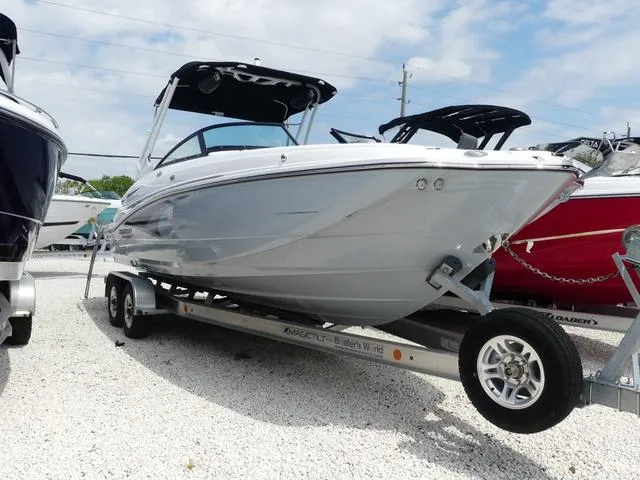Slide: The Image of 2024 Monterey M-65 boat on trailer, sleek design, parked outdoors under blue sky. - 1