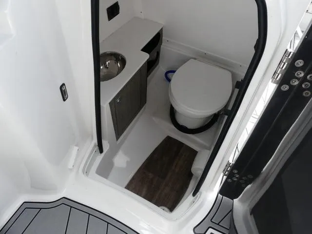Slide: The Image of 2024 Monterey M-65 boat bathroom with toilet, sink, and storage cabinet. - 14