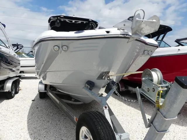 Slide: The Image of 2024 Monterey M-65 boat on trailer, displayed outdoors under a partly cloudy sky. - 2