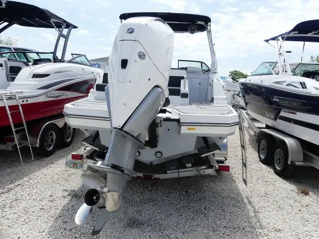 Slide: The Image of 2024 Monterey M-65 boat with powerful outboard motor, displayed on gravel lot. - 5