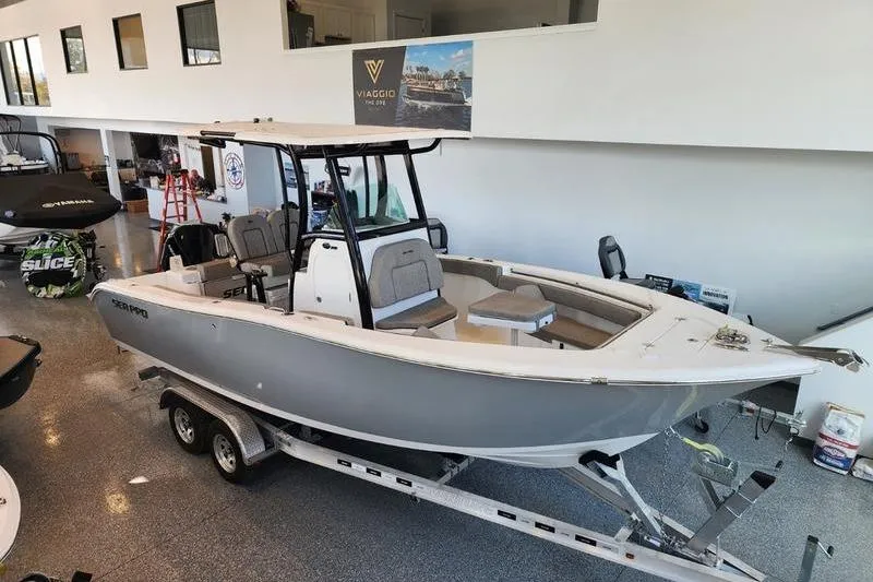 The Image of 2024 Sea Pro 242 Center Console boat displayed indoors on a trailer. - 0