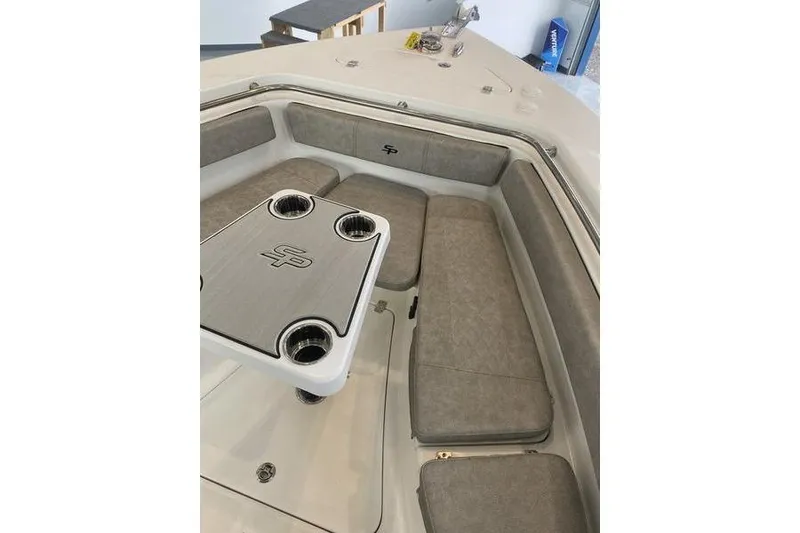 Slide: The Image of 2024 Sea Pro 242 Center Console boat interior with cushioned seating and table. - 42