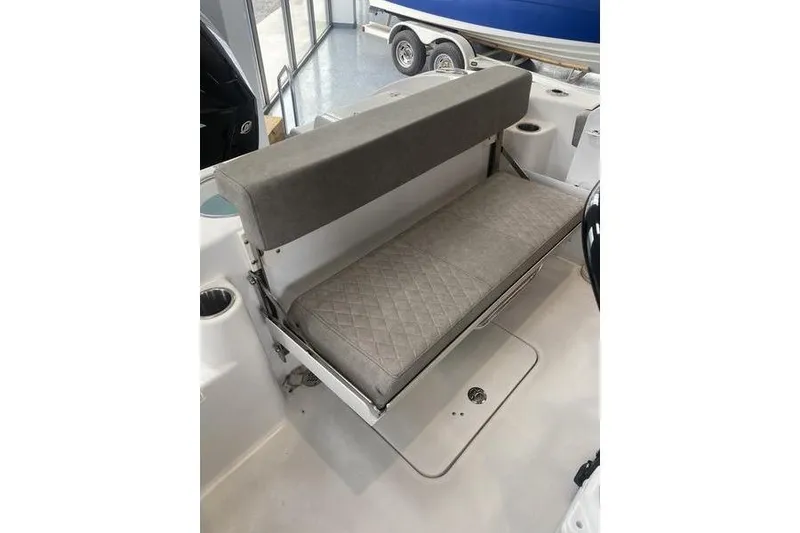 Slide: The Image of 2024 Sea Pro 242 Center Console boat with cushioned seating and storage compartment. - 52
