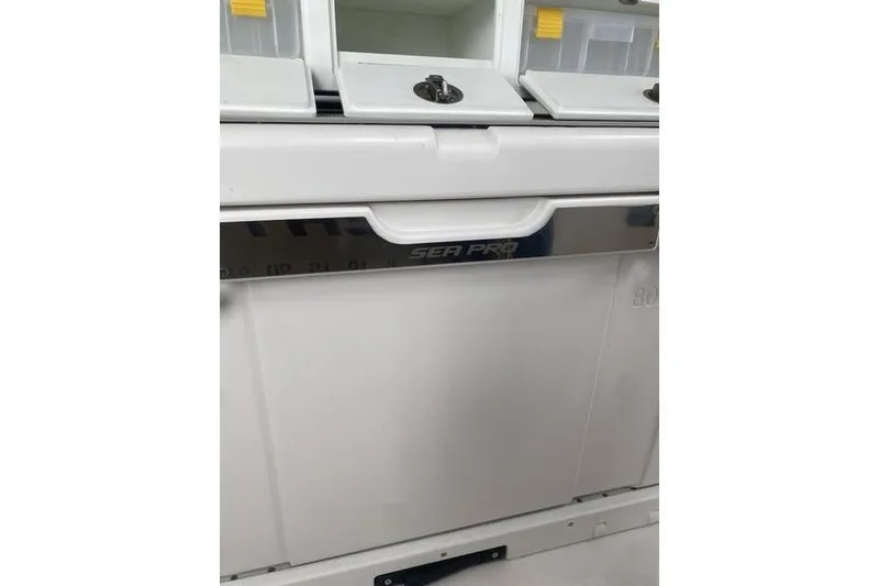 Slide: The Image of 2024 Sea Pro 242 Center Console storage compartments with secure latches and sleek design. - 53