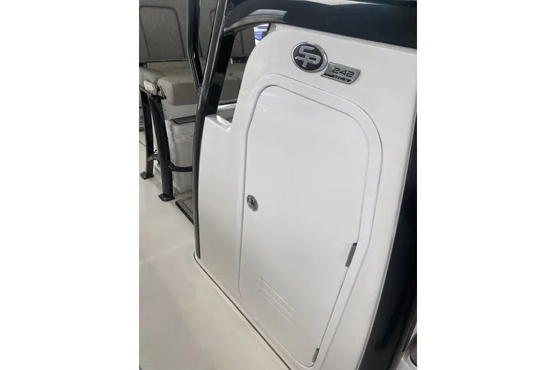 Slide: The Image of 2024 Sea Pro 242 Center Console boat interior door with logo and seating. - 59