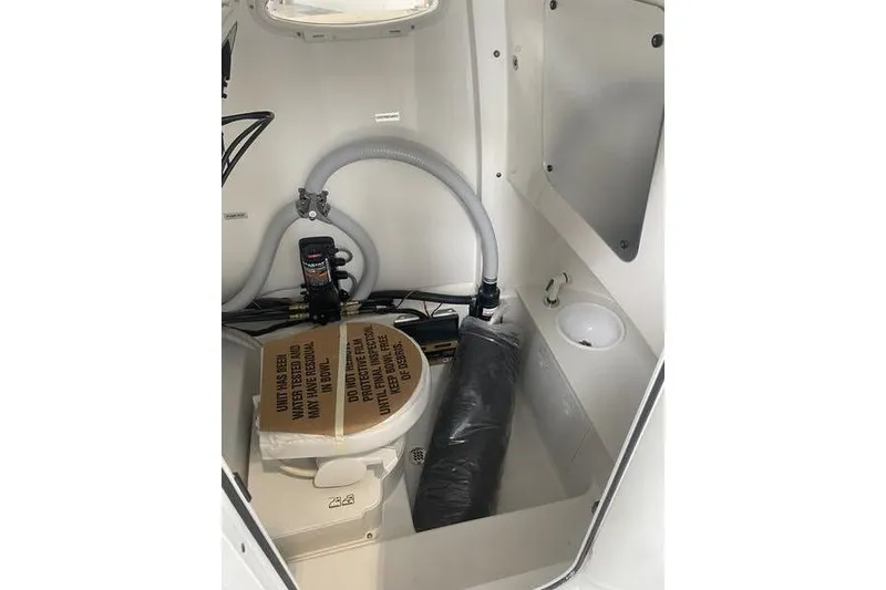 Slide: The Image of 2024 Sea Pro 242 Center Console boat interior with toilet and plumbing components. - 60