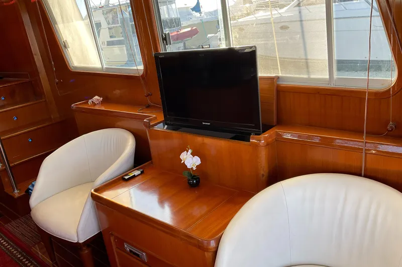 Slide: The Image of Luxurious Integrity 45 yacht interior with TV, white chairs, and wooden furnishings, 2012 model. - 16