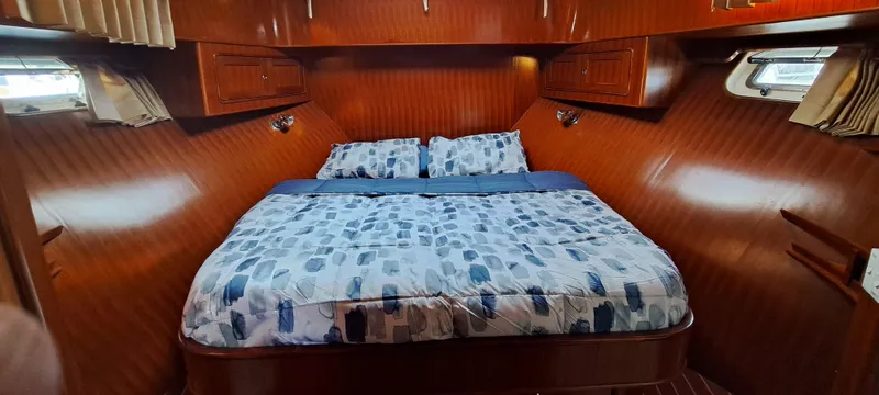Slide: The Image of 2012 Integrity 45 yacht bedroom with wooden interior and cozy bed. - 19