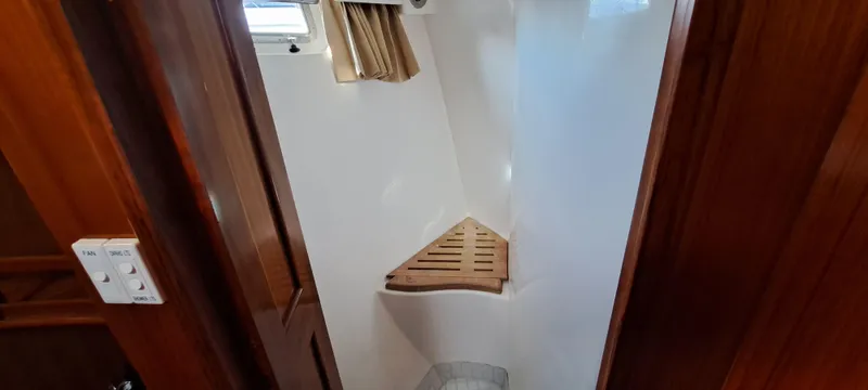 Slide: The Image of 2012 Integrity 45 boat interior shower with wooden seat and window. - 21