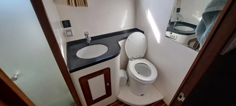 Slide: The Image of Compact bathroom in a 2012 Integrity 45 boat with sink, toilet, and mirror. - 28