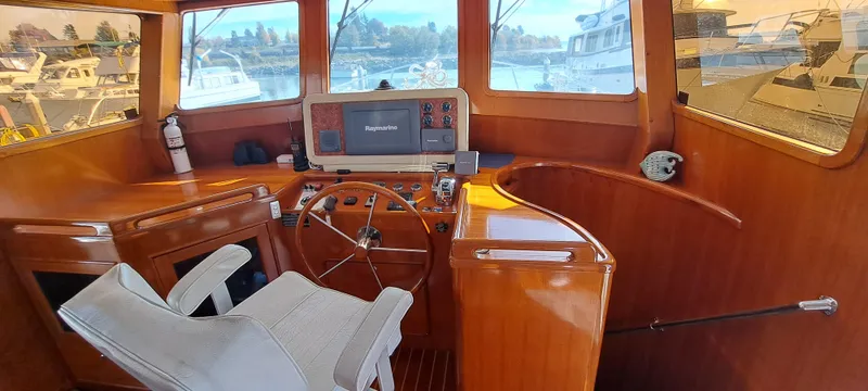 Slide: The Image of Interior helm of a 2012 Integrity 45 boat with wooden finish and navigation equipment. - 32