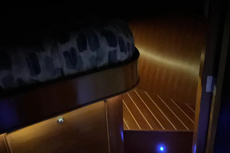 Slide: The Image of Dimly lit cabin interior of 2012 Integrity 45 yacht with wooden flooring and cozy bedding. - 34