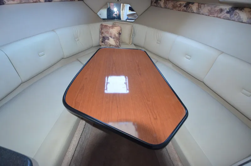 Slide: The Image of Interior of 2000 Chaparral Signature 270 boat with cushioned seating and wooden table. - 11