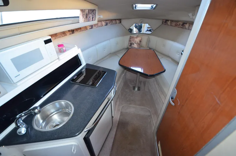 Slide: The Image of 2000 Chaparral Signature 270 cabin interior with kitchenette, sink, and dining area. - 13