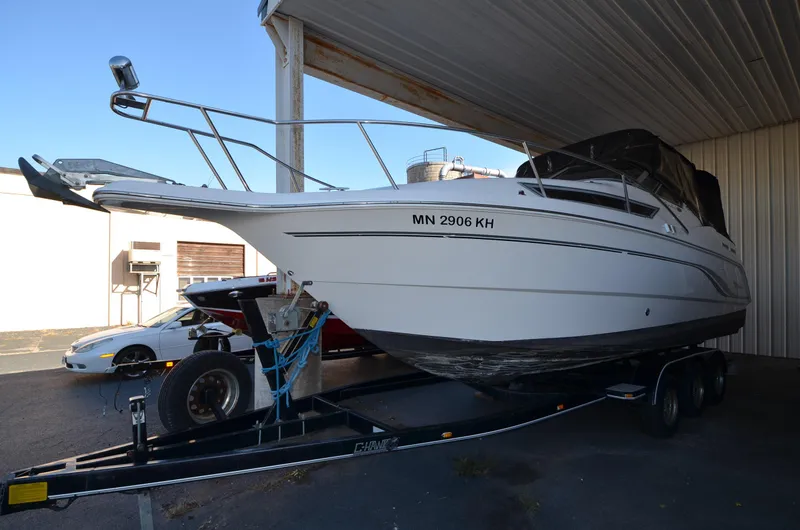 Slide: The Image of 2000 Chaparral Signature 270 boat on trailer, parked under a shelter. - 2