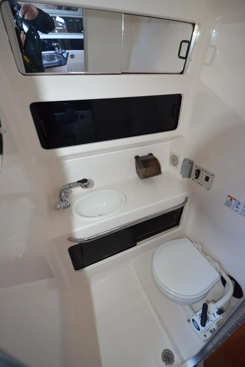 Slide: The Image of 2000 Chaparral Signature 270 boat bathroom with sink, toilet, and mirror. - 25