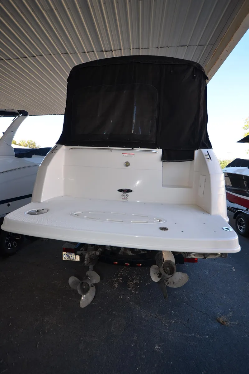 Slide: The Image of 2000 Chaparral Signature 270 boat, rear view under shelter, showcasing swim platform and dual propellers. - 3