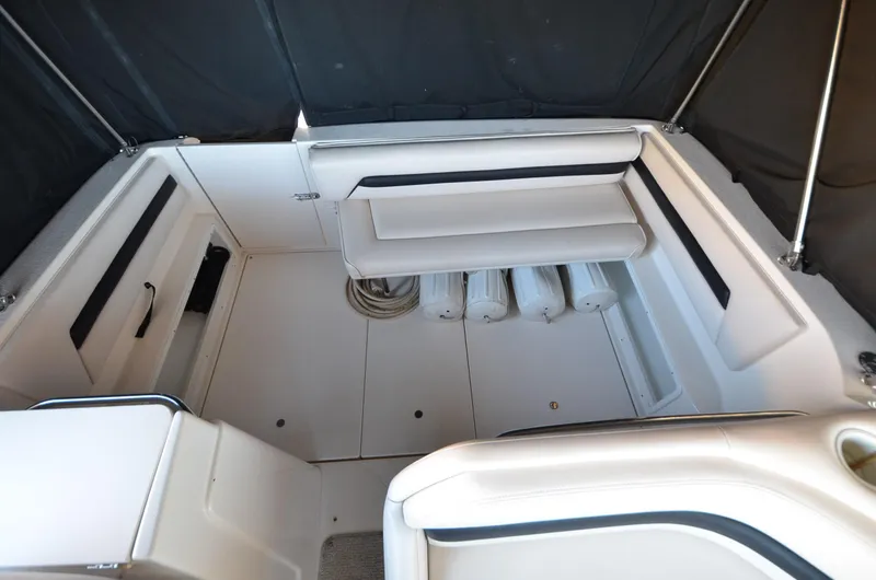 Slide: The Image of 2000 Chaparral Signature 270 boat interior with white seating and storage compartments. - 5