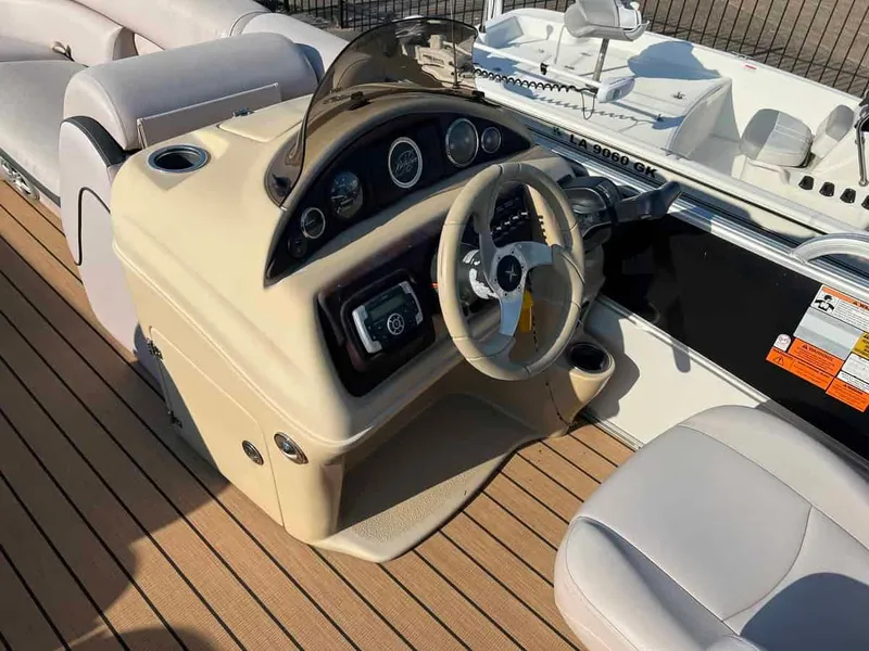 Slide: The Image of 2015 Berkshire 230 CL boat dashboard and steering wheel on teak deck. - 8