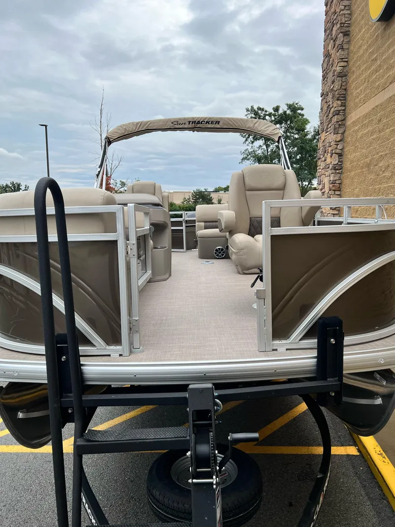 Slide: The Image of 2024 Sun Tracker SportFish 20 DLX pontoon boat with beige seating and canopy. - 2