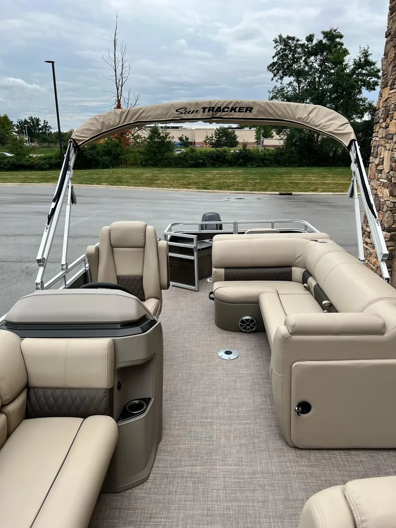 Slide: The Image of 2024 Sun Tracker SportFish 20 DLX pontoon boat with beige seating and canopy. - 3