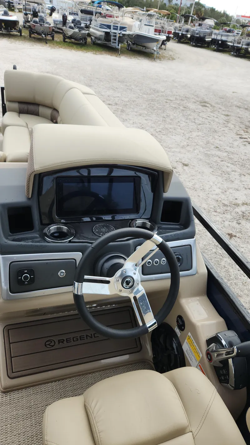 Slide: The Image of 2024 Regency 230 LE3 boat dashboard with steering wheel and control panel. - 1