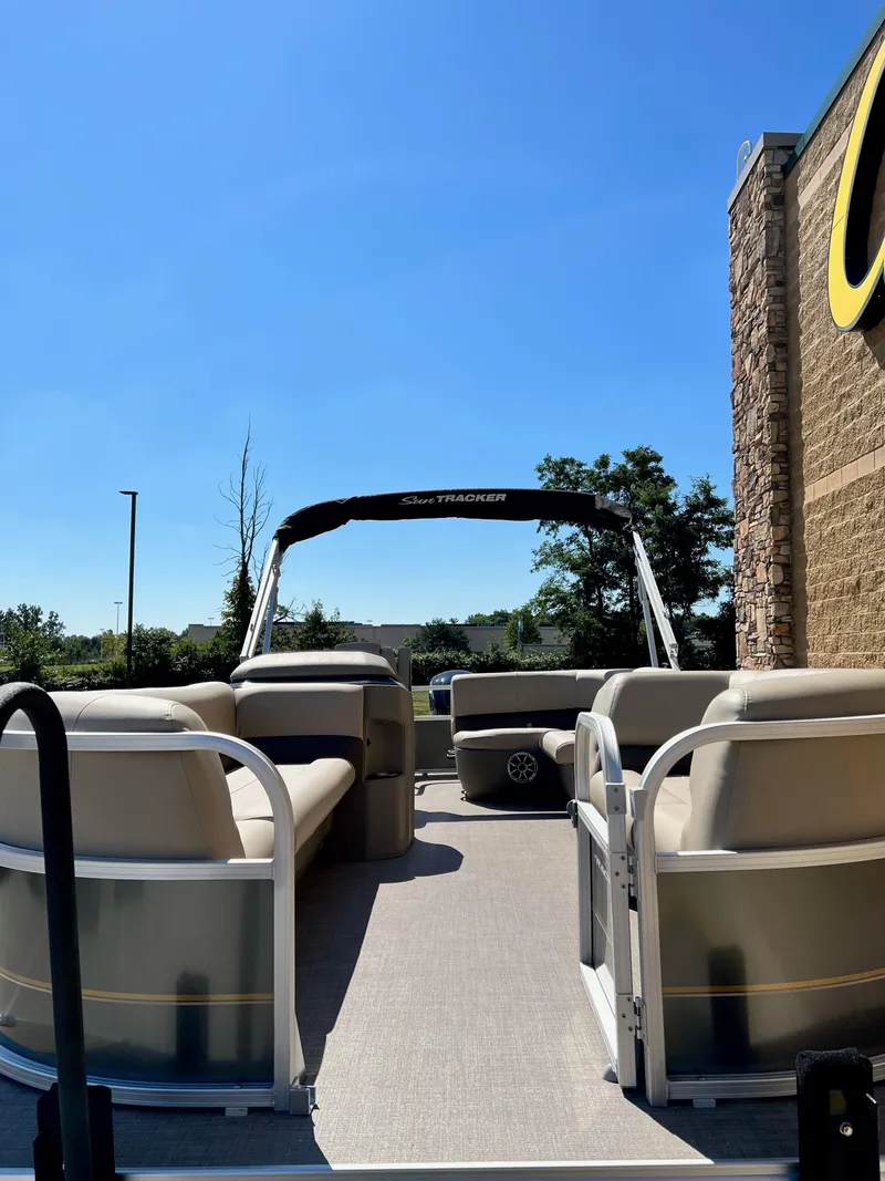 Slide: The Image of 2024 Sun Tracker Party Barge 18 DLX pontoon boat on display outdoors. - 2