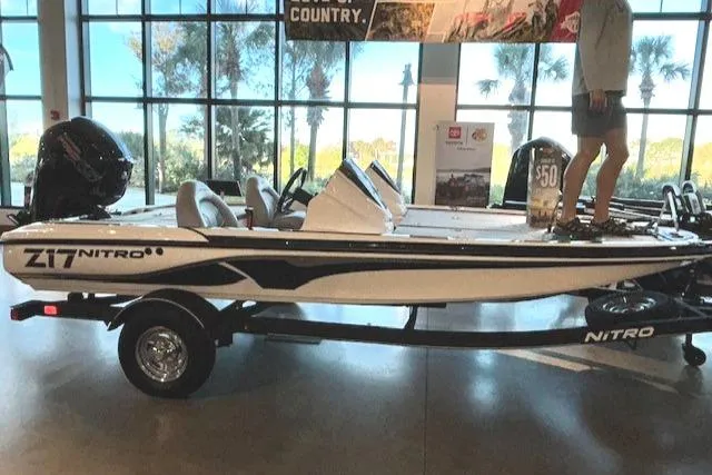Slide: The Image of 2024 Nitro Z17 boat on display indoors with trailer. - 1