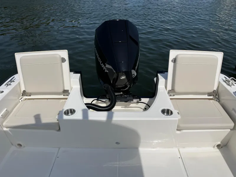 Slide: The Image of 2024 Boston Whaler 210 Montauk boat with dual seats and outboard motor on calm water. - 11