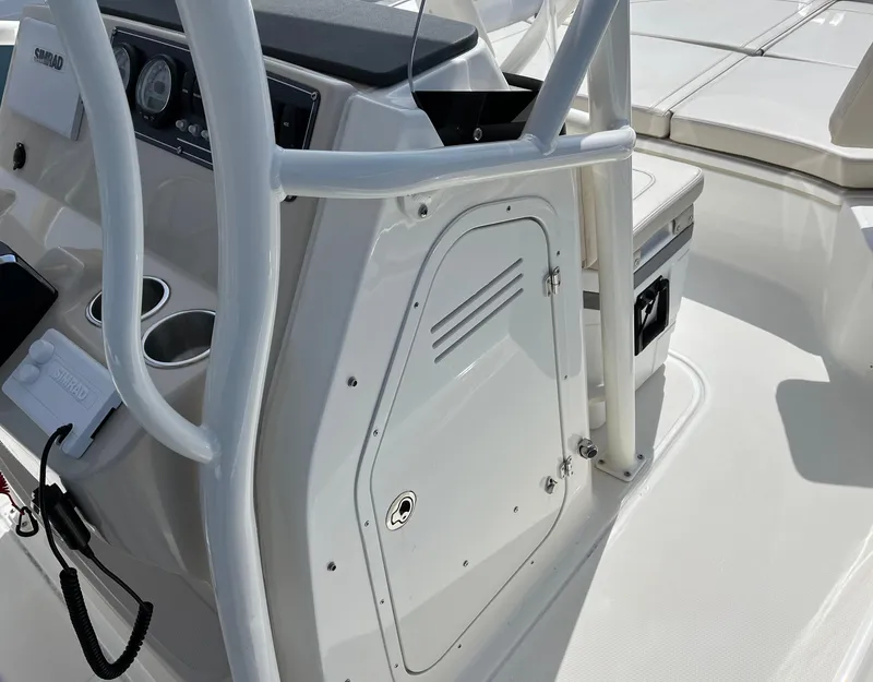 Slide: The Image of 2024 Boston Whaler 210 Montauk console with storage compartment and cup holders. - 20