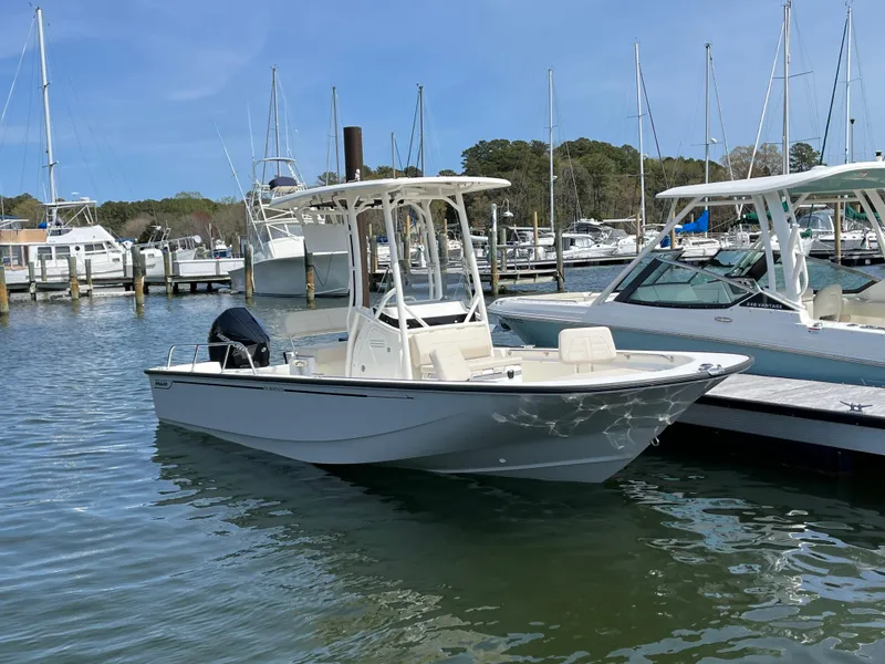 Slide: The Image of 2024 Boston Whaler 210 Montauk boat docked at a marina with other vessels. - 23