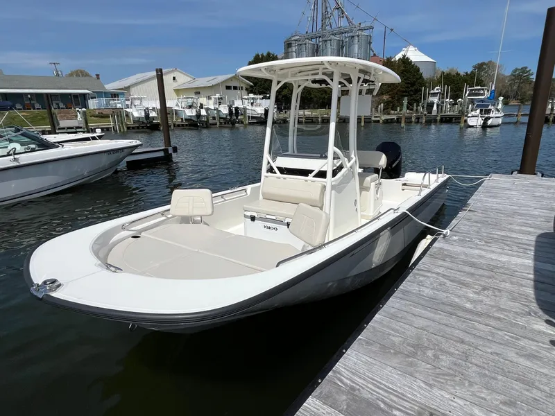 Slide: The Image of 2024 Boston Whaler 210 Montauk boat docked at a marina, showcasing sleek design and spacious deck. - 25