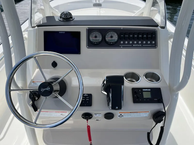 Slide: The Image of 2024 Boston Whaler 210 Montauk boat dashboard with steering wheel and control panel. - 4
