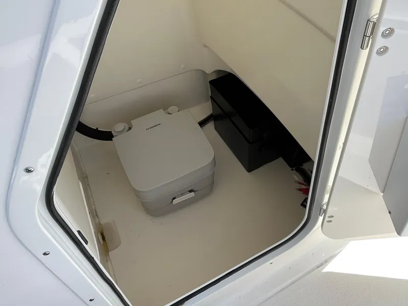 Slide: The Image of 2024 Boston Whaler 210 Montauk interior storage compartment with portable toilet. - 5