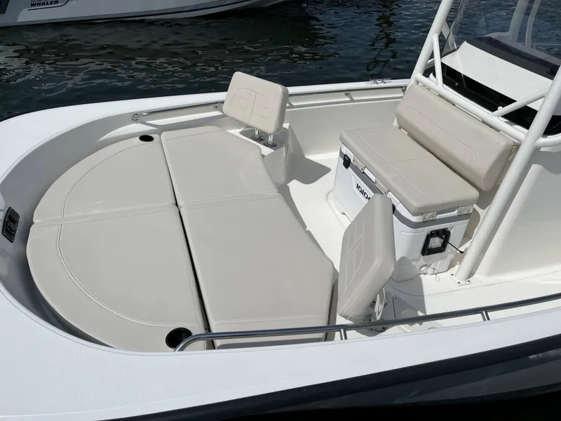 Slide: The Image of 2024 Boston Whaler 210 Montauk boat interior with cushioned seating and storage. - 6
